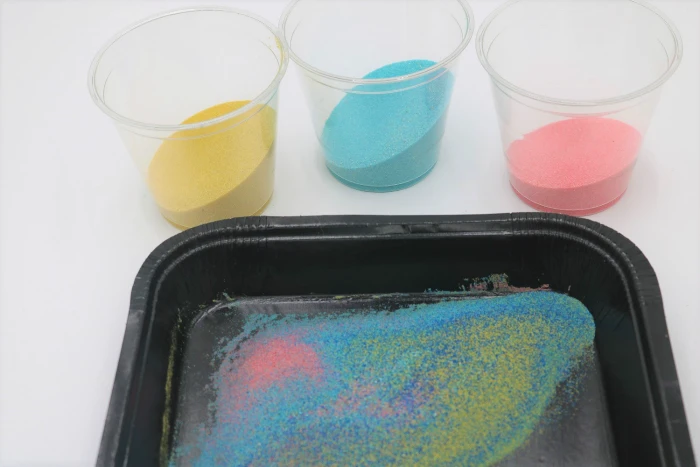 It's easy to create gorgeous colored sand art with adhesive or sticky boards.